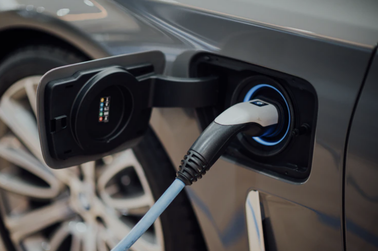 Electric vehicle charger plugged into car